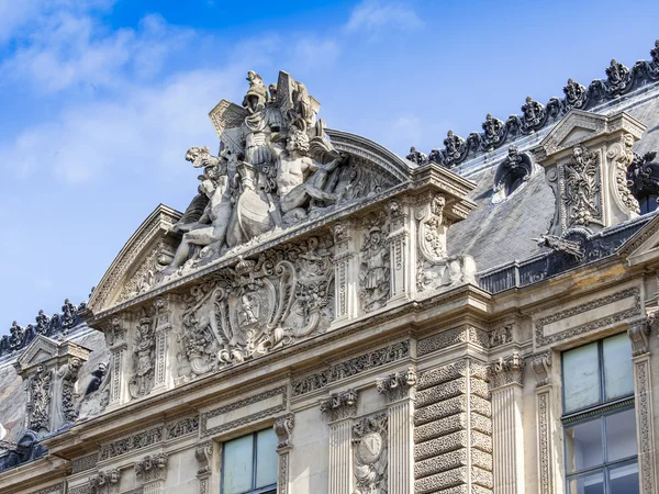 Parijs, Frankrijk, op augustus 29, 2015. Fragment van een van de gevels van het Louvre paleis. Nu is Louvre een van de grootste musea van de wereld zowel de beroemde architectonische en historische monument. — Stockfoto