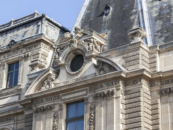 Parijs, Frankrijk, op augustus 29, 2015. Fragment van een van de gevels van het Louvre paleis. Nu is Louvre een van de grootste musea van de wereld zowel de beroemde architectonische en historische monument. — Stockfoto