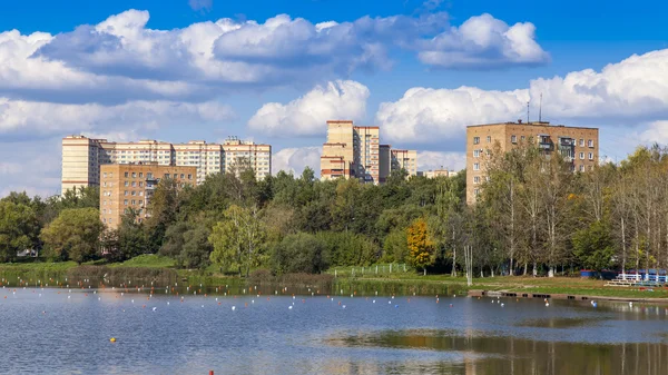 Pushkino, Rusko - 15 září 2015. Podzimní krajina. Multystoried domy na břehu řeky Serebrjanka — Stock fotografie