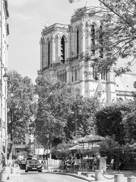 PARIS, FRANCE, le 28 août 2015. Vue urbaine. Typique rue parisienne dans la journée ensoleillée. Tables de café dans la rue. Notre Dame de Paris à distance — Photo