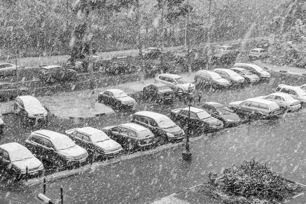 PUSHKINO, RÚSSIA - em 8 de outubro de 2015. Primeira neve. Uma nevasca na cidade. Uma vista da rua e um estacionamento de automóvel no maciço habitado — Fotografia de Stock