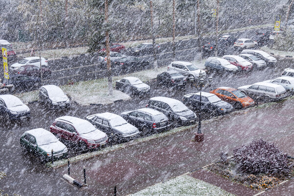ПУШКИНО, РОССИЯ - 8 октября. Первый снег. В городе снежная буря. Вид на улицу и автомобильную стоянку в населенном массиве
