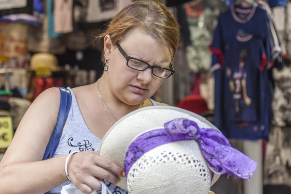 Parigi, Francia, il 31 agosto 2015. La giovane donna prova un cappello in negozio di souvenir — Foto Stock