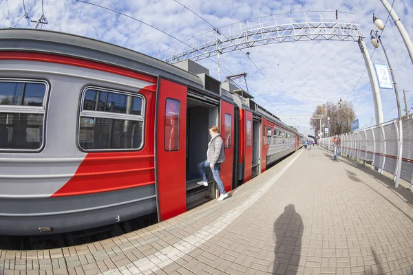 PUSHKINO, RUSSIA - on OCTOBER 22, 2015. The suburban electric train stopped near a platform. Passengers enter train cars — Stock Photo, Image