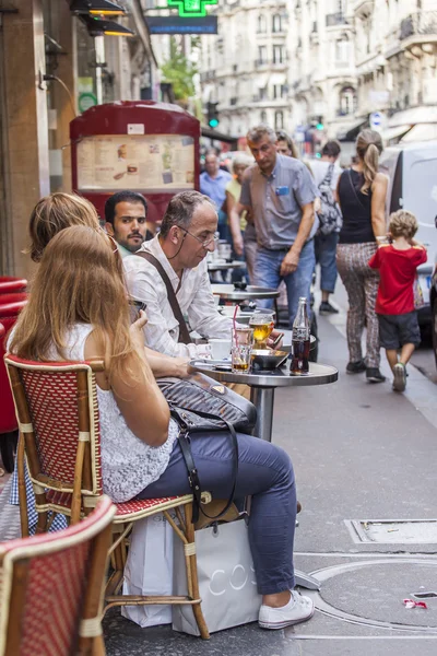 PARIS, FRANCE, on AUGUST 29, 2015. Picturesque summer cafe on the street. People eat and have a rest — Stock Photo, Image