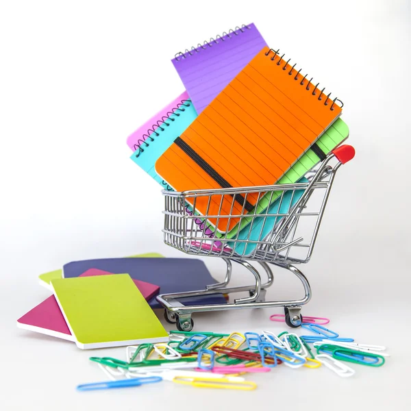 Cuadernos de varios colores en el carrito para ir de compras —  Fotos de Stock