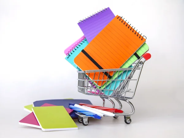 Cuadernos de varios colores en el carrito para ir de compras —  Fotos de Stock