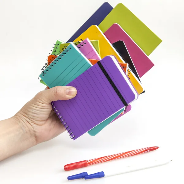 Montón áspero de cuadernos en fundas de varios colores en una mano —  Fotos de Stock