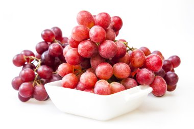 Küme kırmızı üzüm beyaz bir kare kase