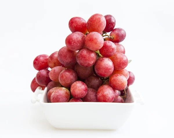 Cluster of red grapes in a white square bowl — Stock Photo, Image