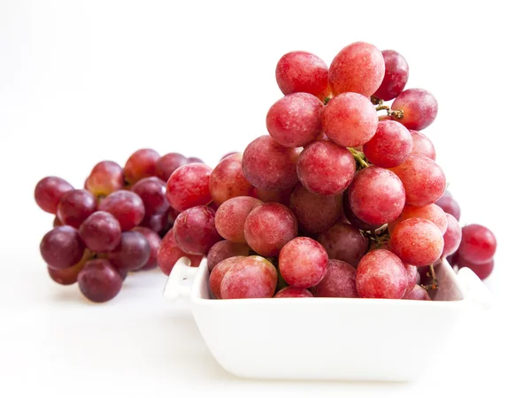 Cluster of red grapes in a white square bowl — Stock Photo, Image