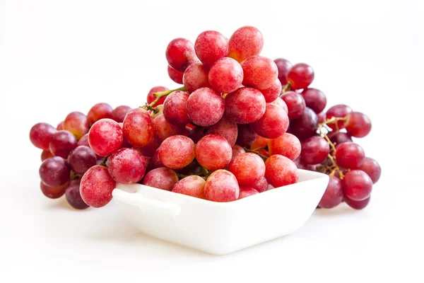 Cluster of red grapes in a white square bowl — Stock Photo, Image