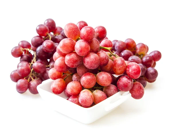 Cluster of red grapes in a white square bowl — Stock Photo, Image