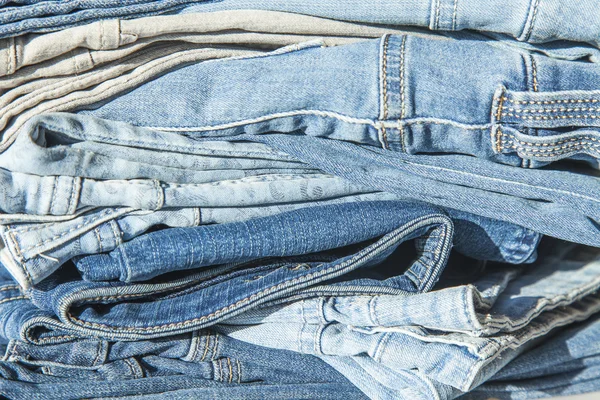Pile de jeans de différentes nuances sur une vitrine de magasin — Photo