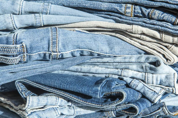 Pile de jeans de différentes nuances sur une vitrine de magasin — Photo