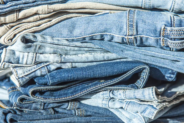 Stapel van jeans van verschillende tinten in een Toon-venster van winkel — Stockfoto