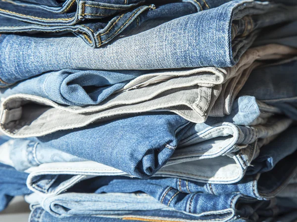 Stapel van jeans van verschillende tinten in een Toon-venster van winkel — Stockfoto