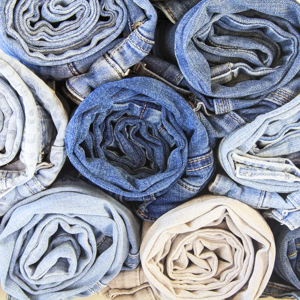 The jeans curtailed in a roll on a counter of shop — Stock Photo, Image