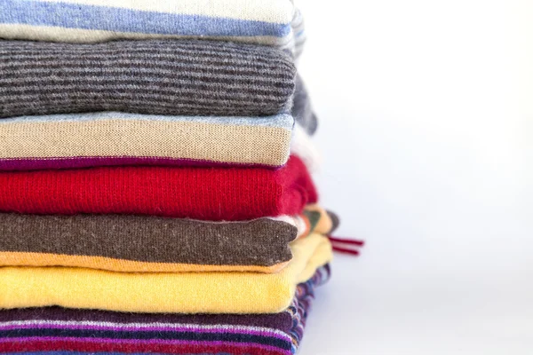 Pile of woolen jumpers of various colors on a show-window of shop — Stock Photo, Image