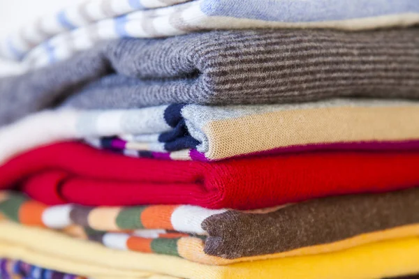 Pile of woolen jumpers of various colors on a show-window of shop — Stock Photo, Image