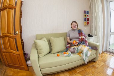 Kadın bir kanepe odasında oturur