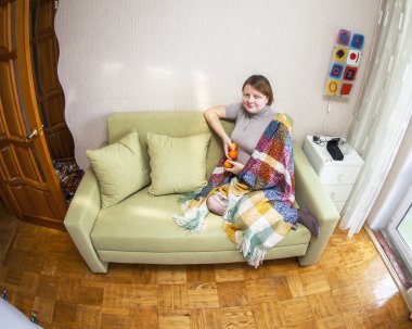 Kadın bir kanepe odasında oturur