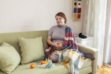 Kadın bir kanepe odasında oturur