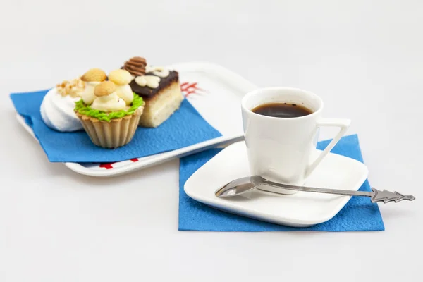 Cup with black coffee and a plate with cakes on a background — Stock Photo, Image