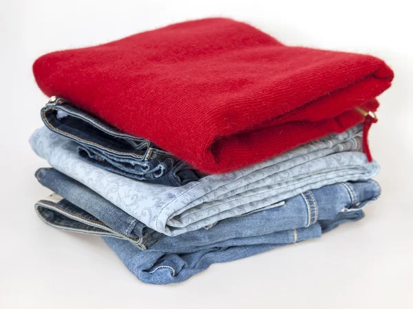 Saltador vermelho e jeans em um balcão de loja — Fotografia de Stock