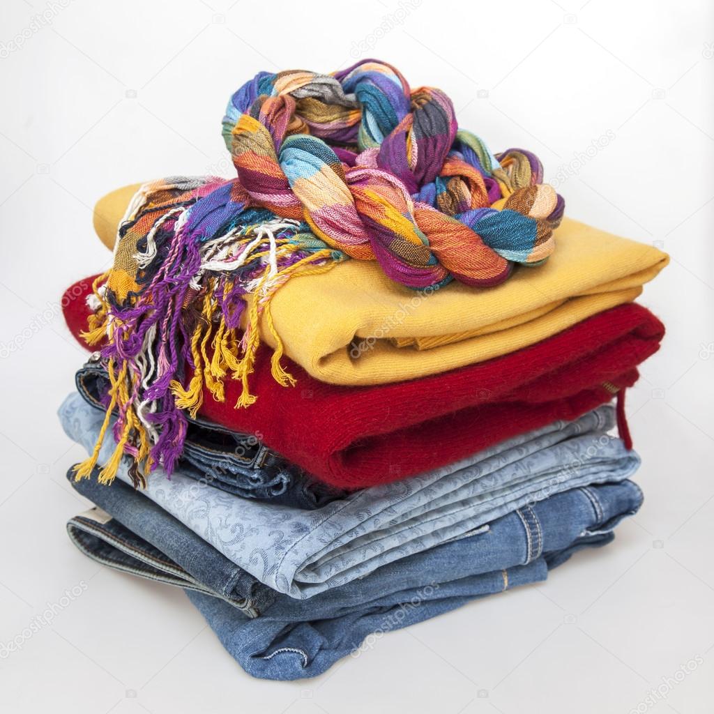 Multi-colored jumpers and jeans on a counter of shop