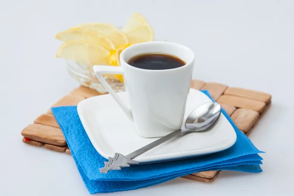 Чашка кофе эспрессо и ломтики лимона на заднем плане — стоковое фото