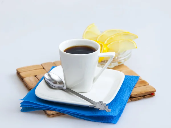 Чашка кофе эспрессо и ломтики лимона на заднем плане — стоковое фото