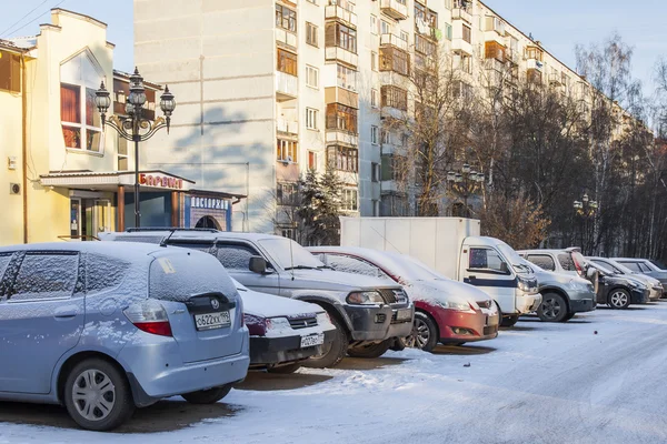 Городской пейзаж в зимний день. Вид на парковку автомобилей на городской улице — стоковое фото