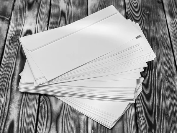 Pilha áspera de envelopes poste branco em uma mesa de madeira — Fotografia de Stock