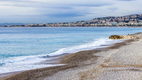 ニース、フランス、2016 年 1 月 7 日。ビーチと波とサーフィンのライン。遠くの堤防 — ストック写真