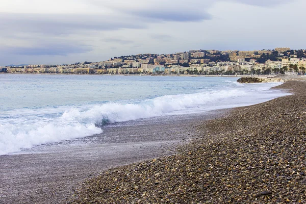 ニース、フランス、2016 年 1 月 7 日。ビーチと波とサーフィンのライン。遠くの堤防 — ストック写真