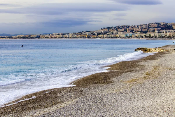 Niza, FRANCIA, en Enero 7, 2016. Una playa y la línea de un oleaje con olas. Arrastramiento en la distancia — Foto de Stock