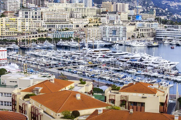 MONTE-CARLO, MONACO, el 10 de enero de 2016. Una vista de las casas en una pendiente de la montaña y yates en la bahía — Foto de Stock