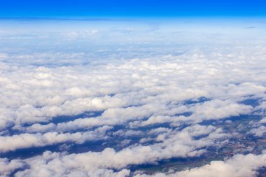 Uçak görünümü penceresinden pitoresk beyaz bulutlar ve dünya yüzeyinde