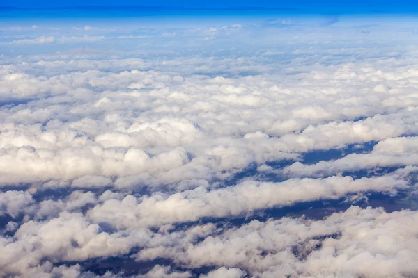 Vue aérienne depuis la fenêtre sur les nuages blancs pittoresques et la surface de la terre — Photo