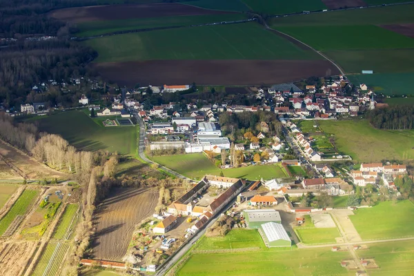 Widok z okna latający samolot na chmury i naziemnej poniżej powierzchni — Zdjęcie stockowe