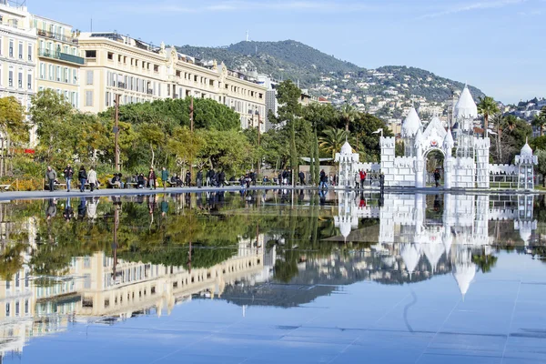 NICE, FRANCIA, il 7 GENNAIO 2016. La fontana piatta nel parco della Promenade du Paillon. Un complesso architettonico di edifici nel viale e il suo riflesso in acqua. La gente cammina su una passeggiata — Foto Stock