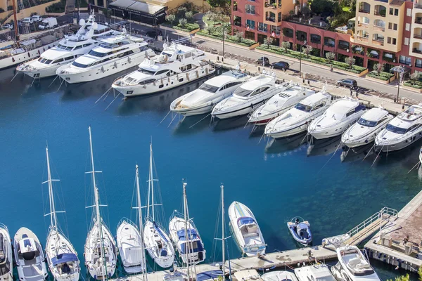 MONTE-CARLO, MONACO, on JANUARY 10, 2016. A view of houses on a slope of the mountain and the yacht at the mooring in a bay — Stock Photo, Image