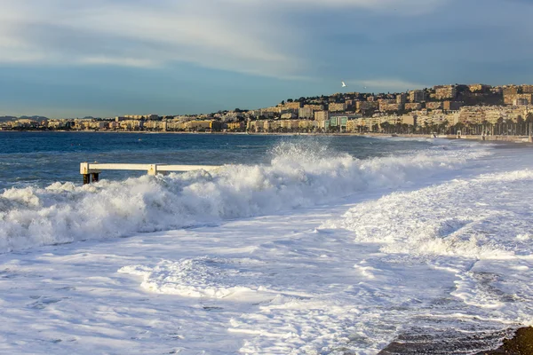 NICE, FRANCIA - el 8 de enero de 2016. Vista de la línea de surf, ola, playa y Promenade des Anglais Embankment, uno de los terraplenes más bellos de Europa — Foto de Stock