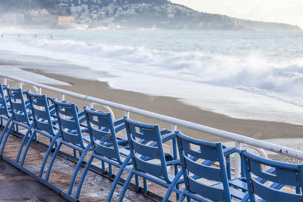 NICE, FRANCE - on JANUARY 8, 2016. Blue chairs for vacationers of Promenade des Anglais, one of the most beautiful embankments of Europe. These chairs are one of city symbols