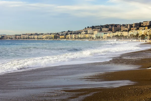 NICE, FRANCIA - el 8 de enero de 2016. Vista de la línea de surf, ola, playa y cielo y terraplén a distancia — Foto de Stock