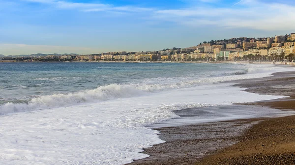 NICE, FRANCIA - el 8 de enero de 2016. Vista de la línea de surf, ola, playa y cielo y terraplén a distancia — Foto de Stock