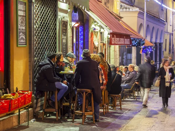 NICE, FRANCIA - el 8 de enero de 2016. Vista nocturna del casco antiguo. La gente descansa y come en la cafetería al aire libre — Foto de Stock