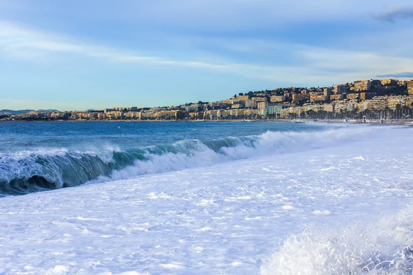 NICE, FRANCIA - el 8 de enero de 2016. Vista de la línea de surf, ola, playa y cielo y terraplén a distancia — Foto de Stock