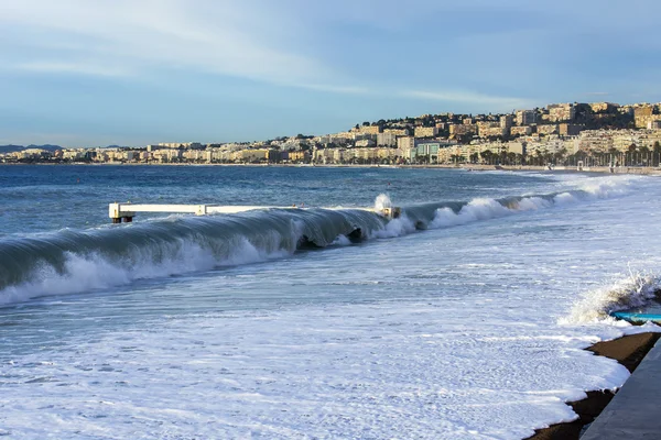 NICE, FRANCIA - el 8 de enero de 2016. Vista de la línea de surf, ola, playa y cielo y terraplén a distancia — Foto de Stock